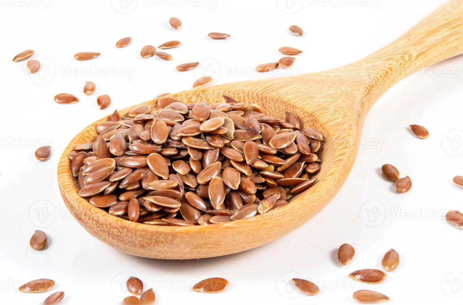 Flax seeds in wooden spoon isolated on white background. photo