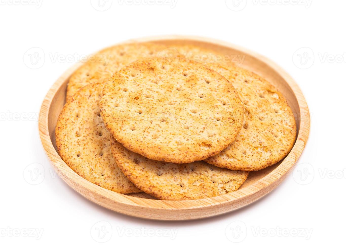 Baked round cracker chips in wooden dish isolated on white background. Wheat cracker chips isolated on white background. Whole wheat cracker isolated on white background with clipping path photo