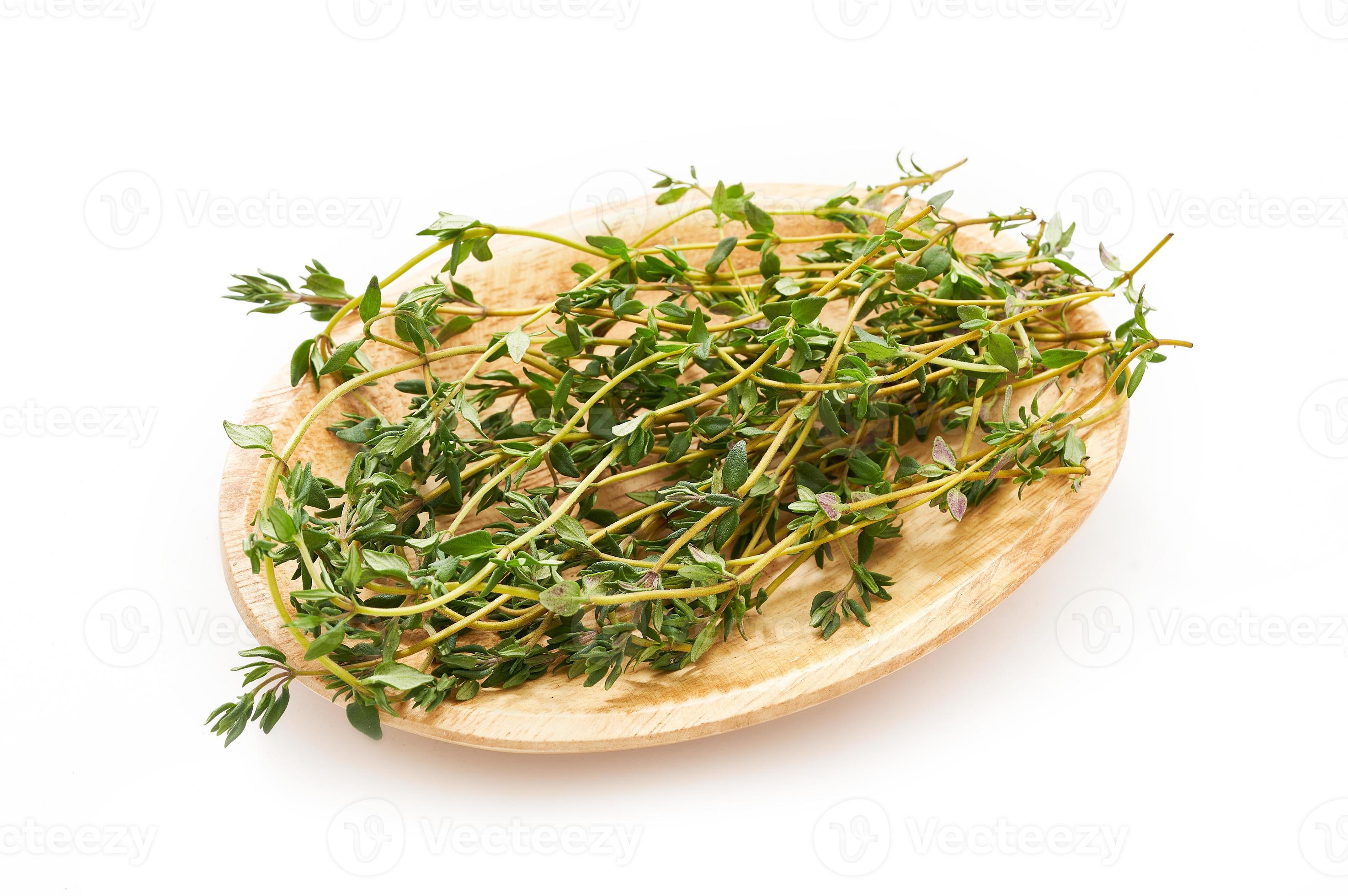 thyme leaves in wood bowl isolated on white background. heap of green