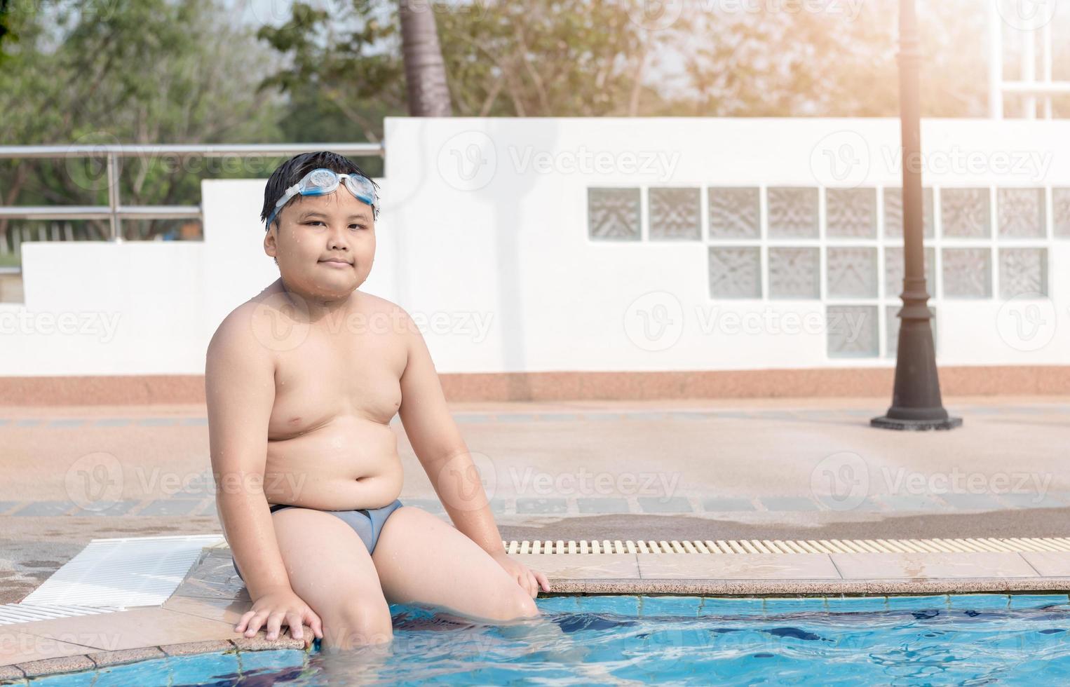 Obese fat boy sit on swimming pool photo