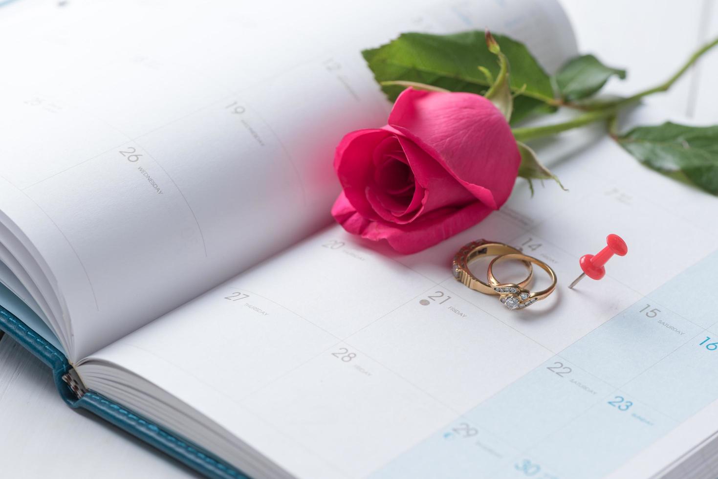 Wedding gold rings and pin on calender. photo