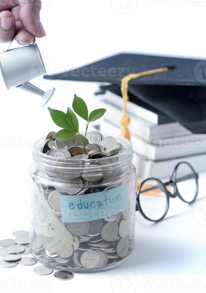 Businessman watering a tree growing out of silver coins on watering pod isolated photo