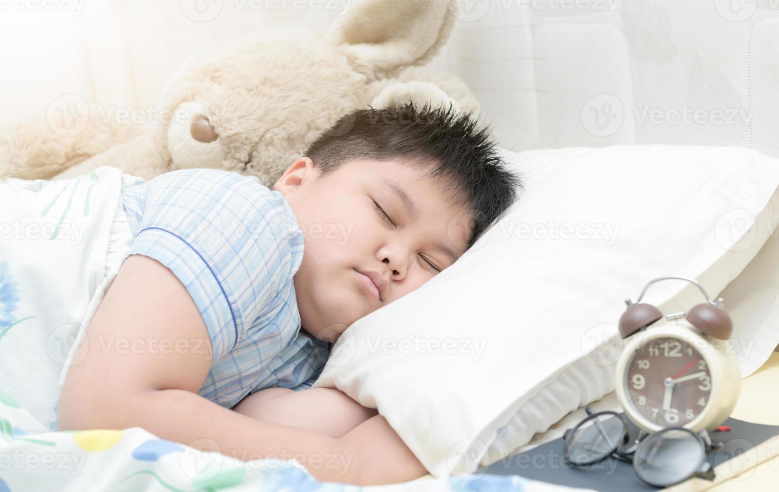 obese fay boy sleep on bed. photo