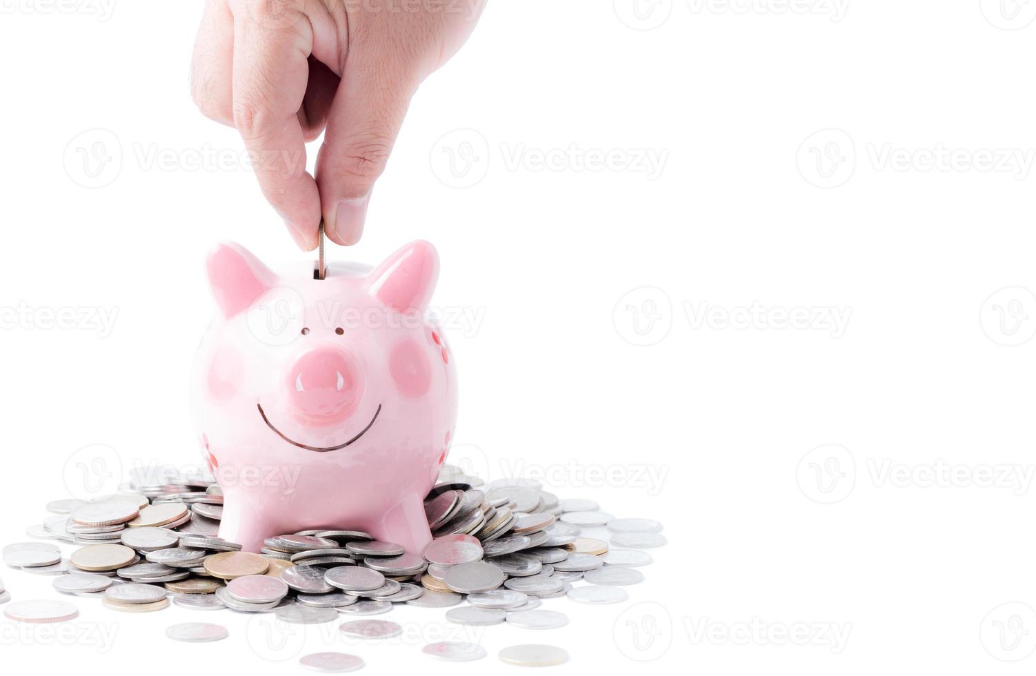 Businessman putting coin into pink piggy bank isolated photo