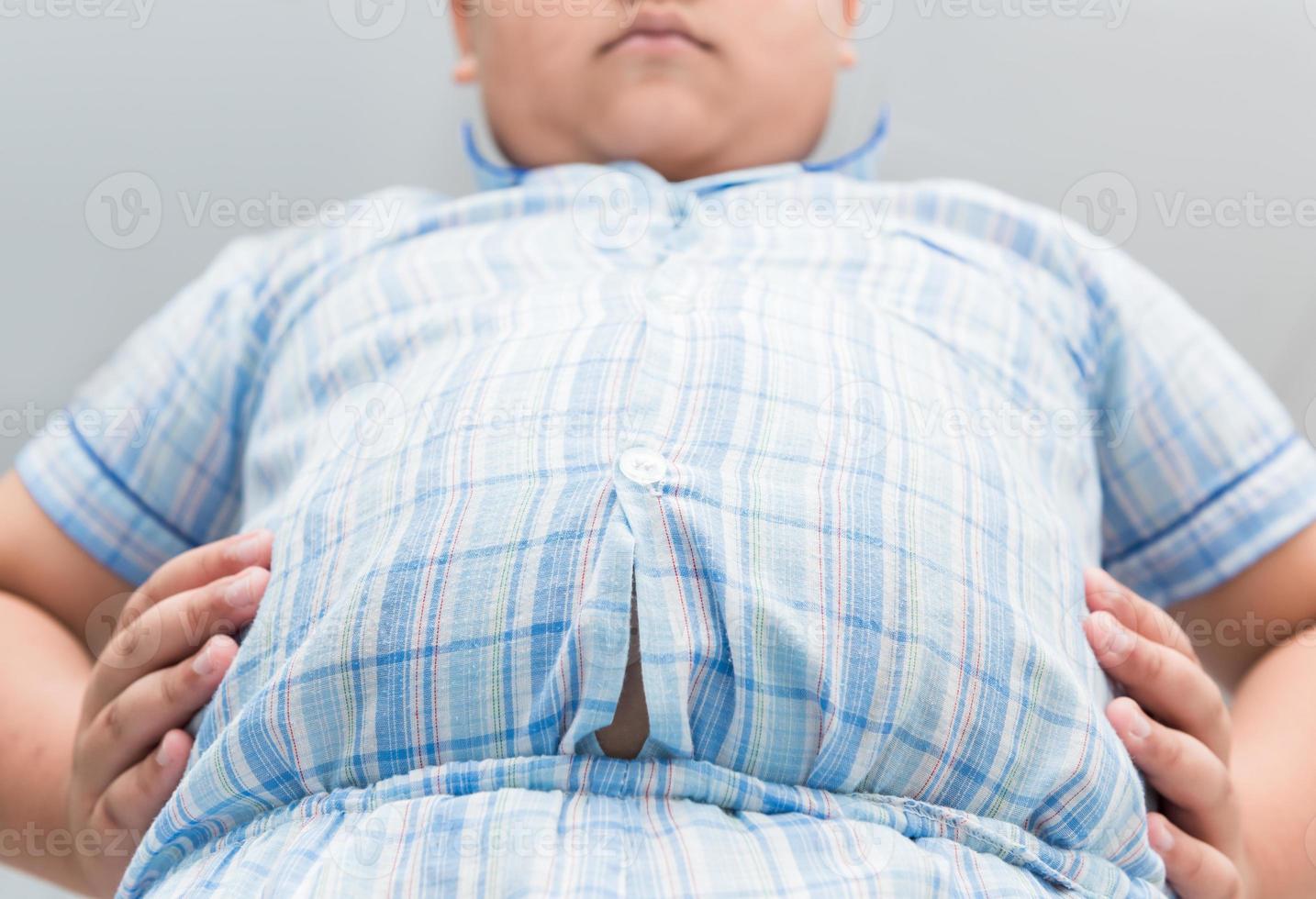 Obese fat boy overweight. Tight shirt of pajamas photo