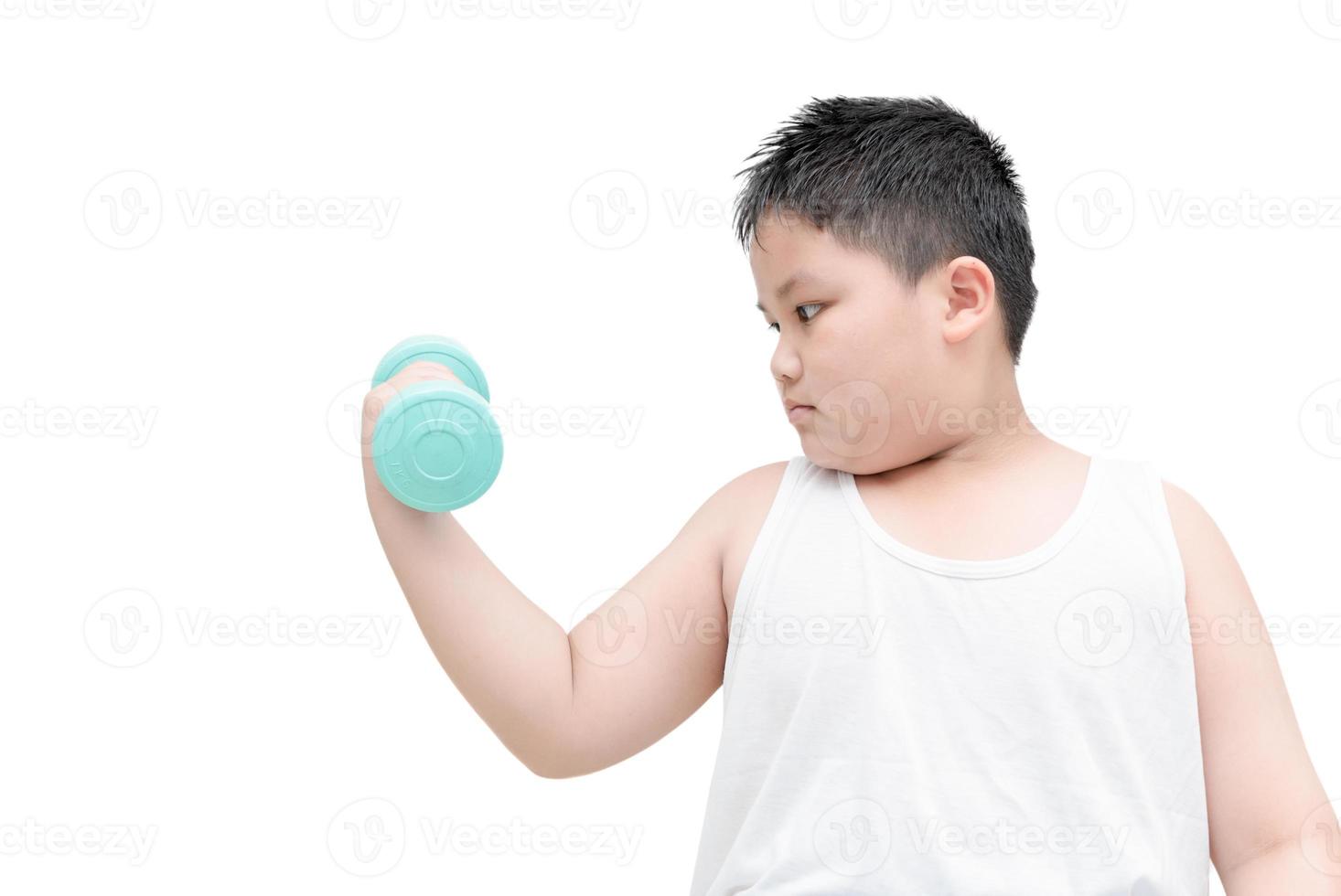 obese fat boy is doing exercises with dumbbells photo