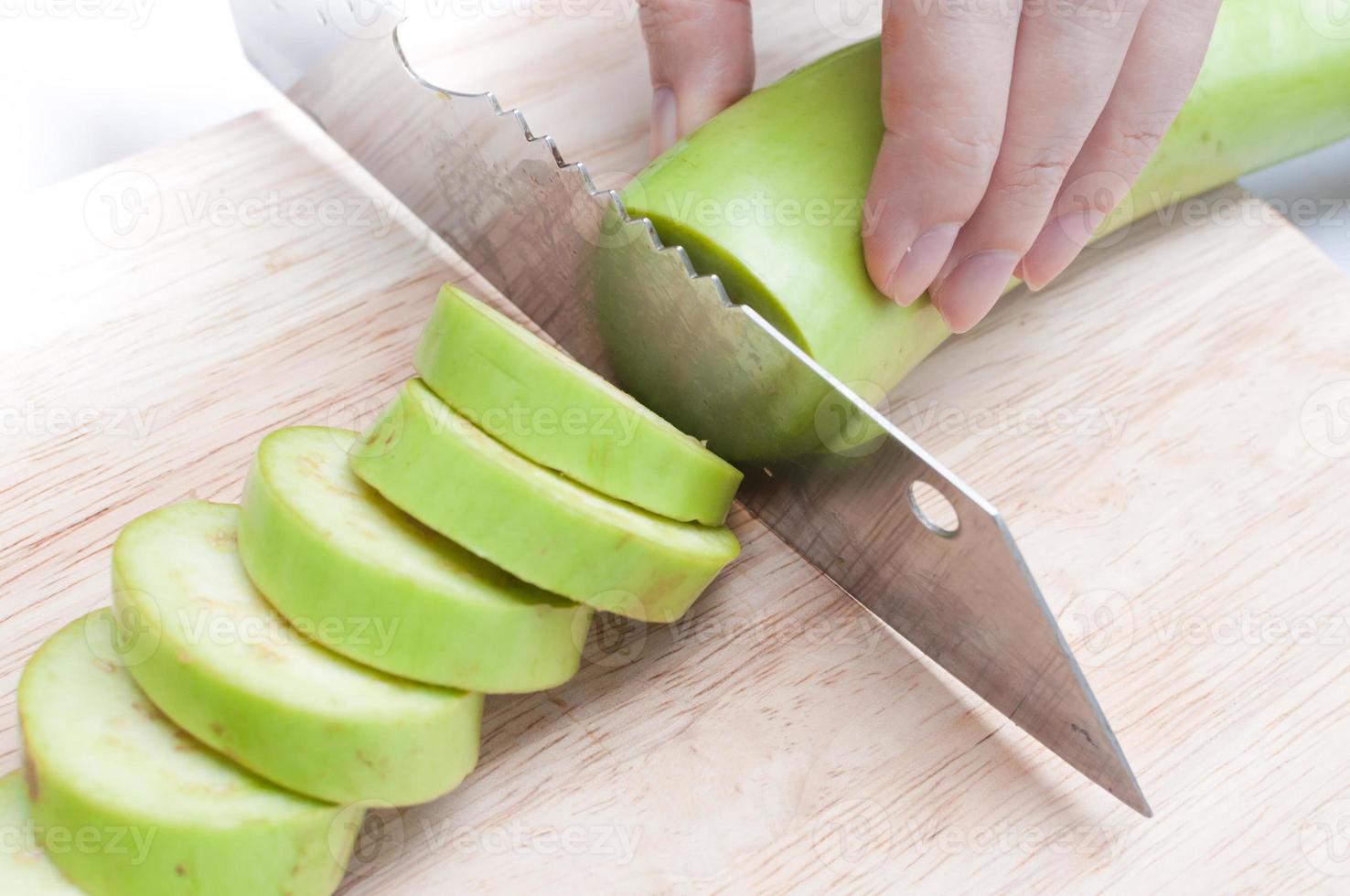 resh green eggplant sliced on wooden board photo
