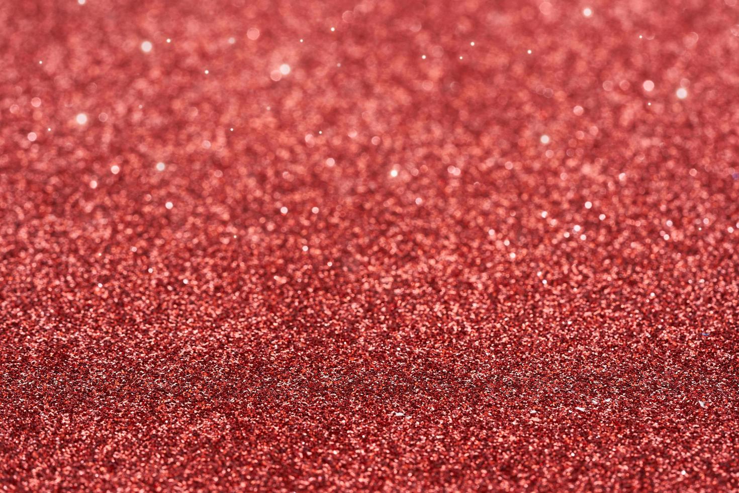 red dust spark glitter texture christmas abstract sparkle background. close up red dust spark glitter texture christmas abstract sparkle background. red bokeh glitter photo