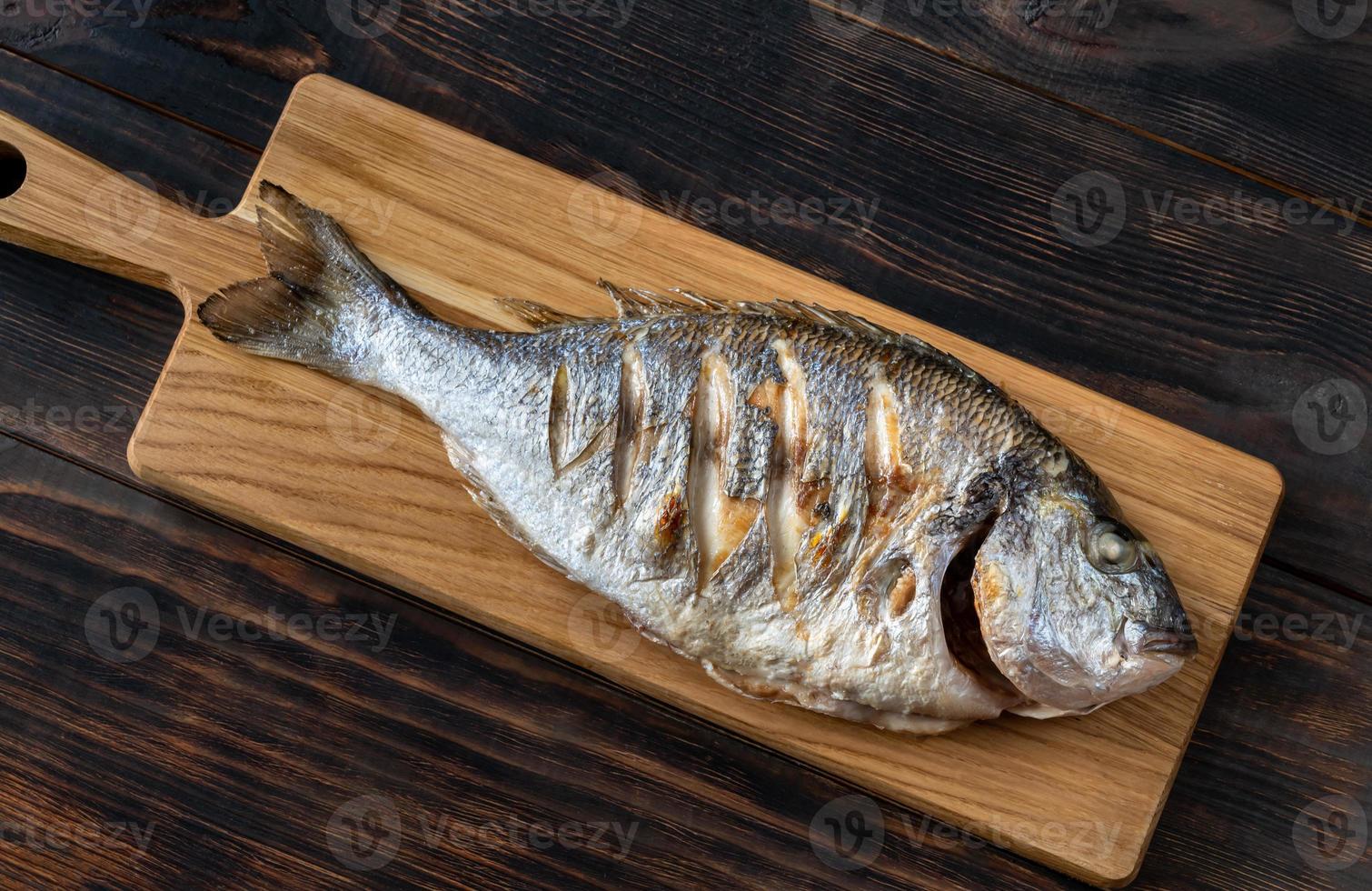 Grilled fish on the wooden board photo