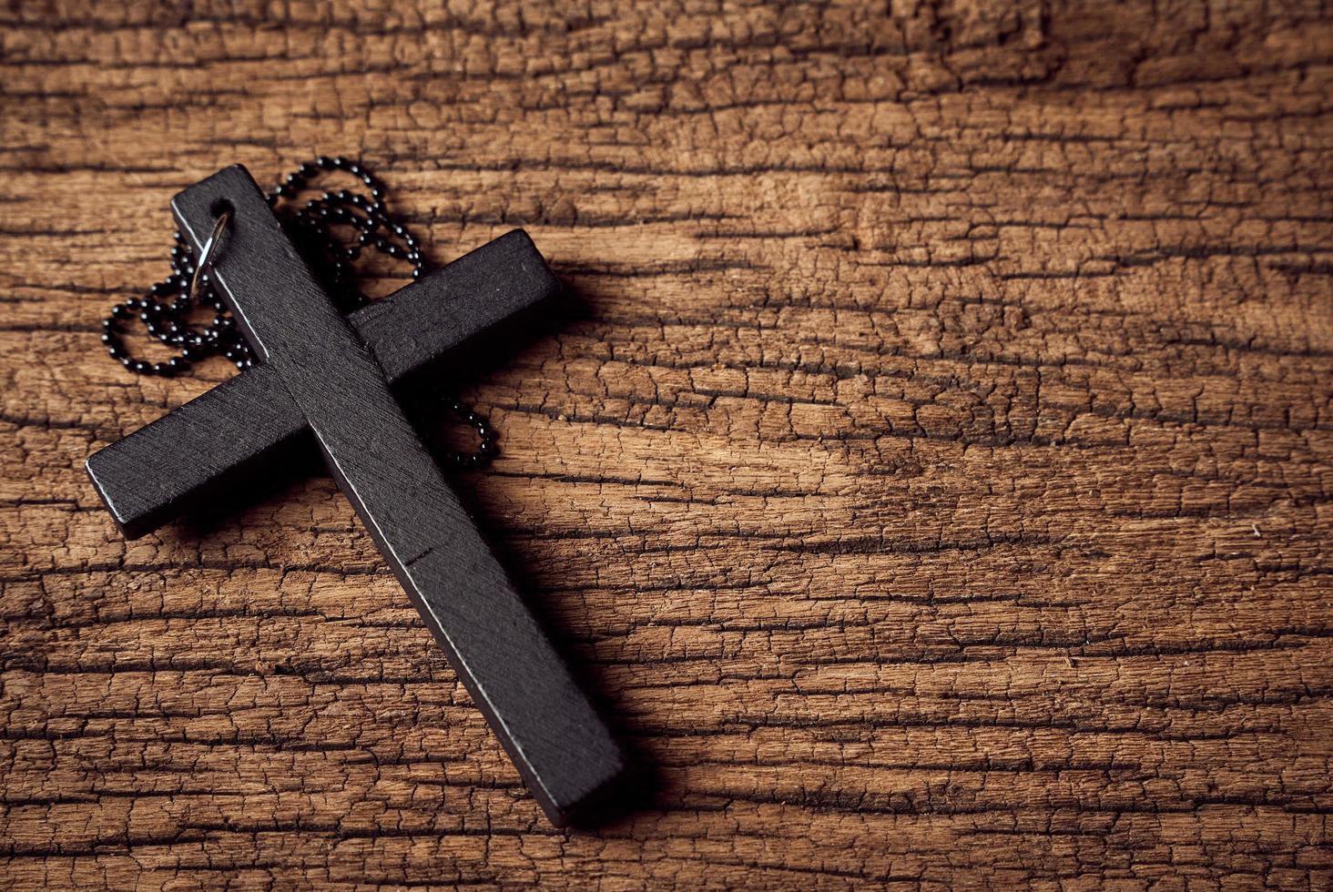 Concept of Christian. close up Jesus Christ black cross on the old wooden table background with copy space photo