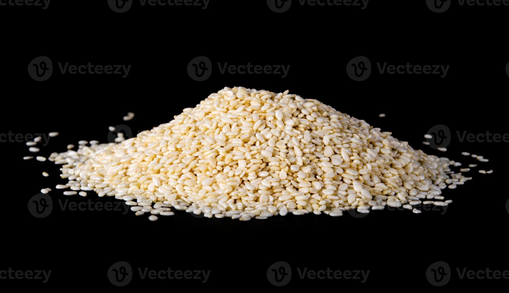 white sesame seeds on black background. organic natural sesame seeds on black background. toasted sesame seeds on black background photo