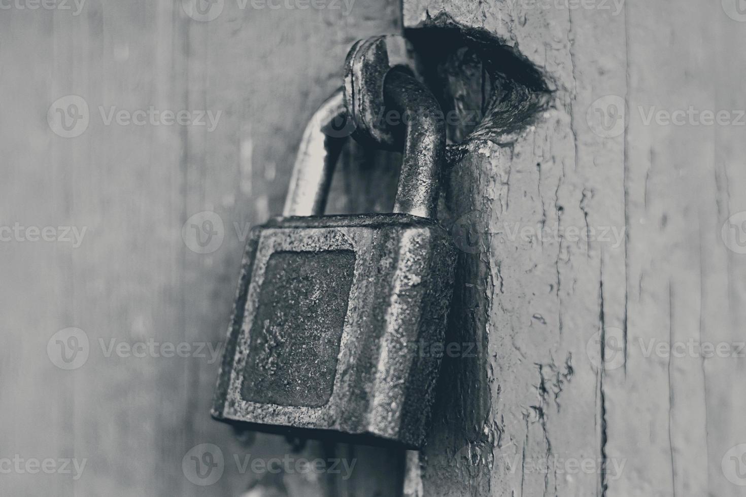 old iron padlock on locked closed door photo