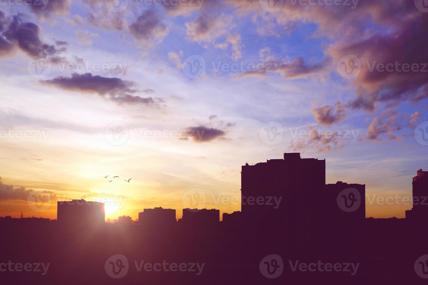 City skyline with buildings silhouettes in sunset sky photo