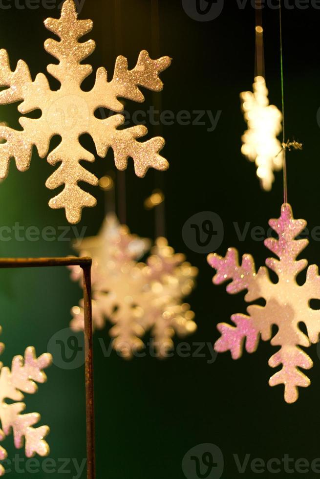 blurred golden snow flakes on dark green background photo