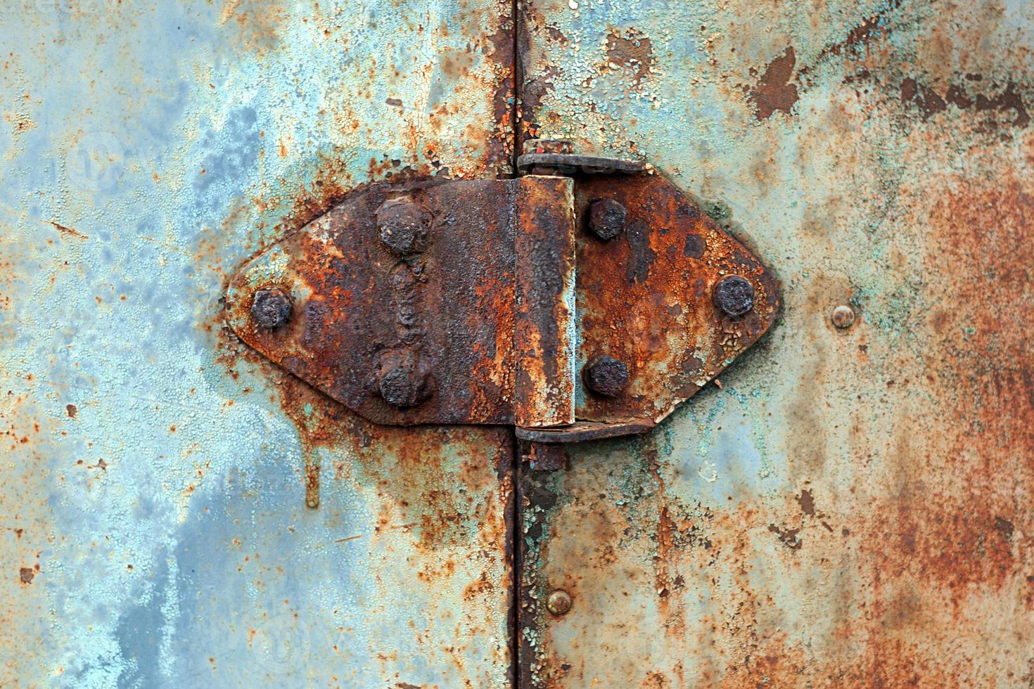 Rusty hinge on old rusted iron door, close-up photo