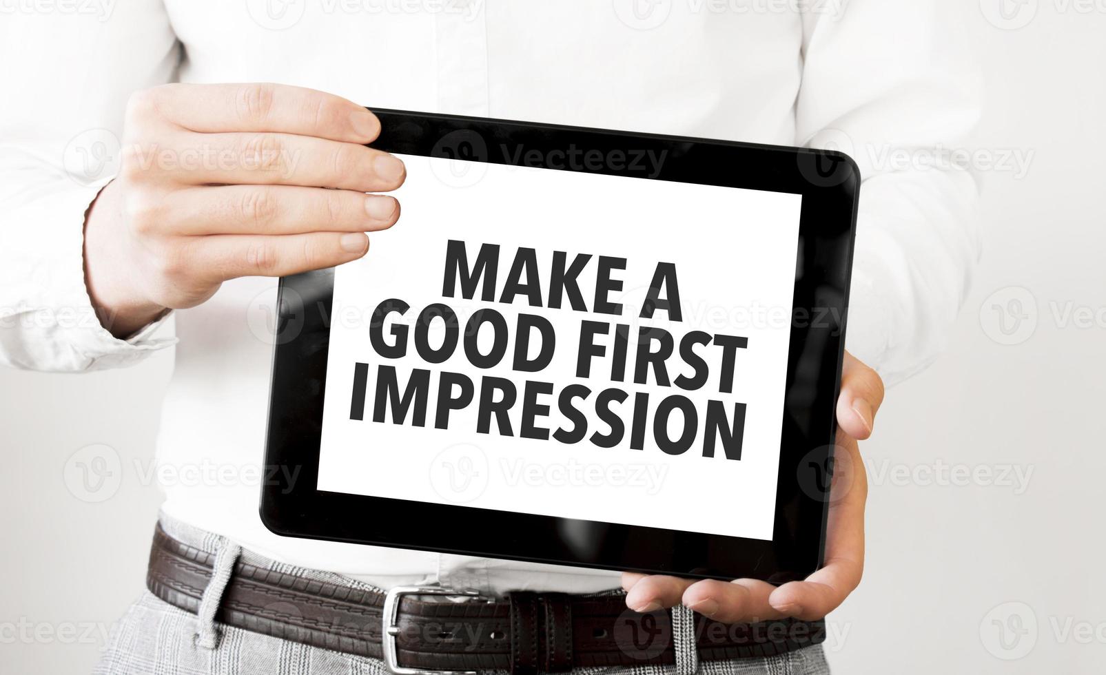 Businessman hold black tablet with text Make a good first impression photo