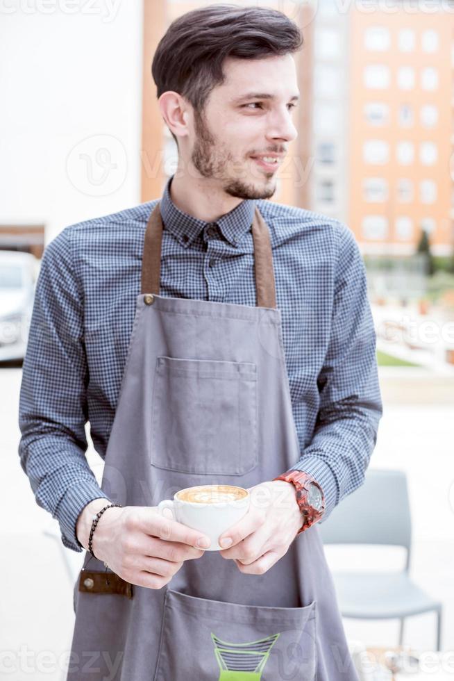 un sonriente barista participación café foto