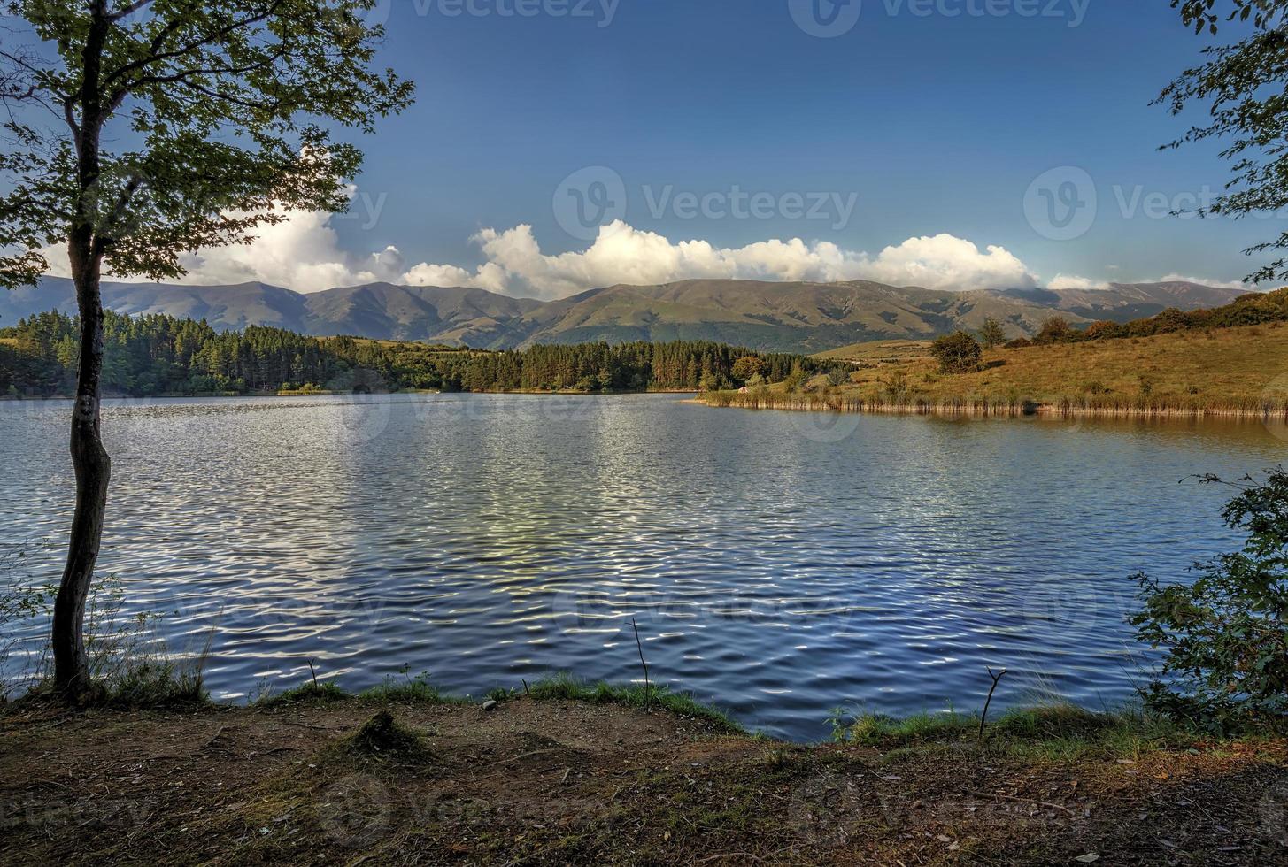 Stunning nature composition. Day view over the lake and mountain. Lake reflected the clouds. photo