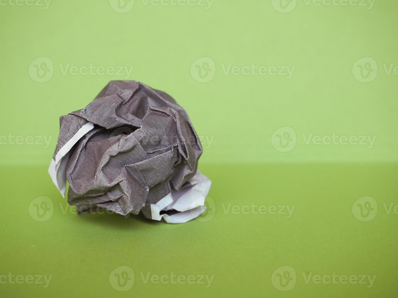 crumpled paper ball over green photo