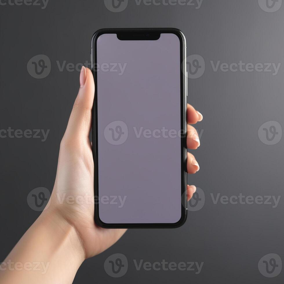 hand holding smartphone with blank screen on gray background. Mock up , photo