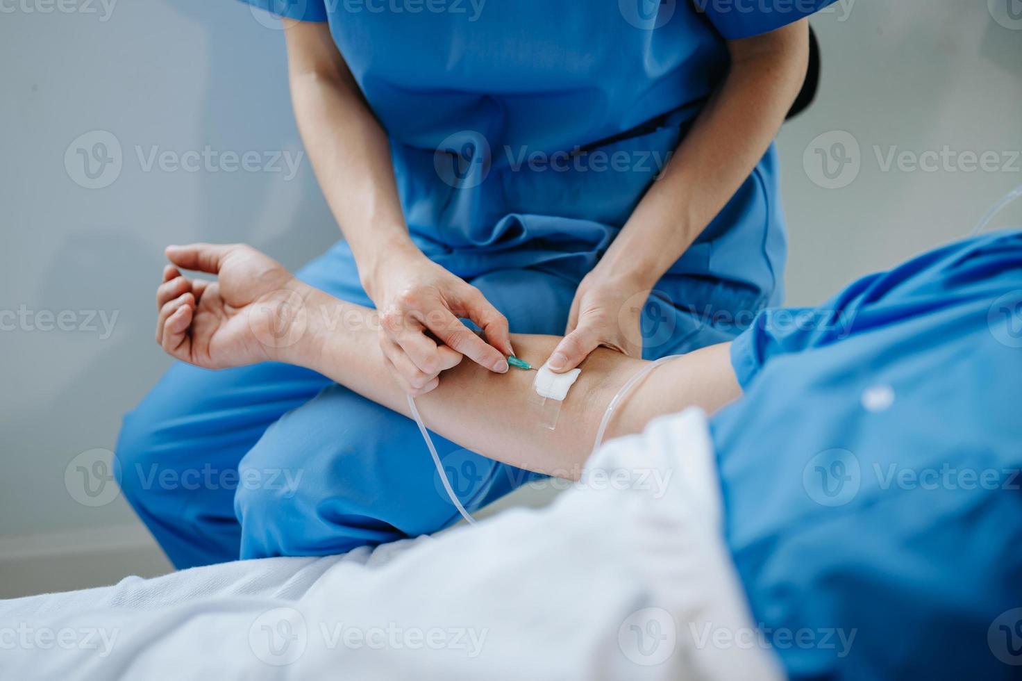 simpático hembra cabeza enfermero haciendo rondas lo hace chequeo en paciente descansando en cama. ella cheques tableta mientras hombre completamente recuperación después exitoso cirugía en hospital foto