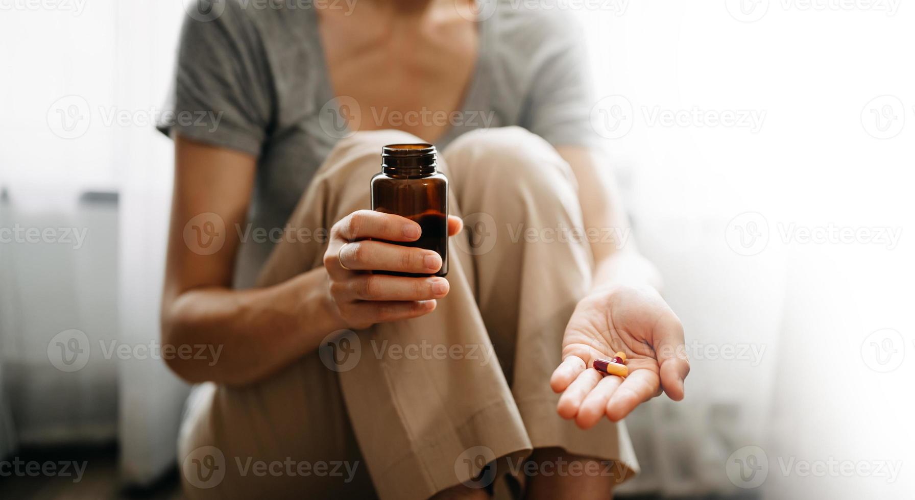 woman hand holding bottle with pills on hand going to take medicaments prescribed by his physician photo