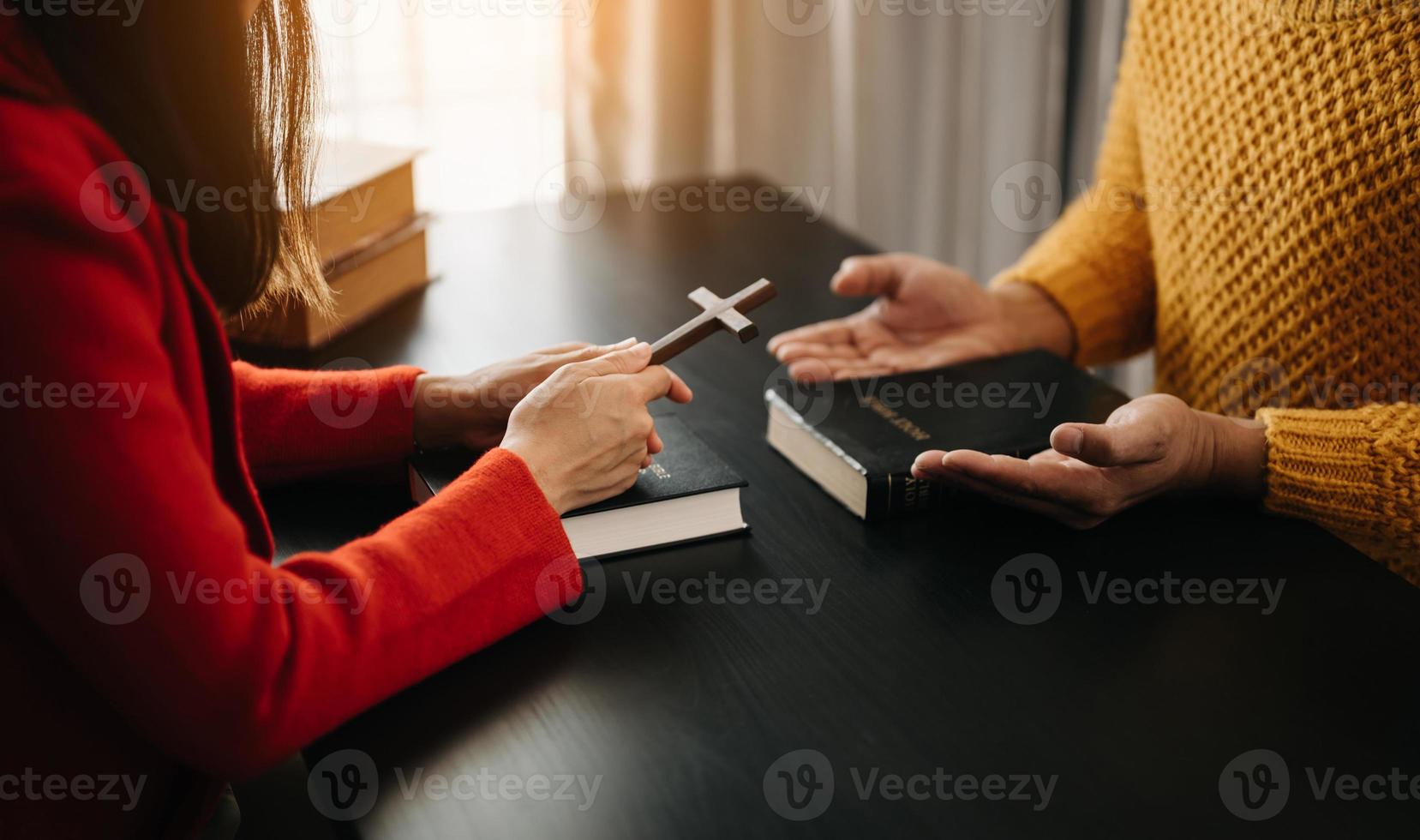 dos personas leyendo y estudiando la biblia en casa y rezando juntas. estudiando la palabra de dios con amigos. foto