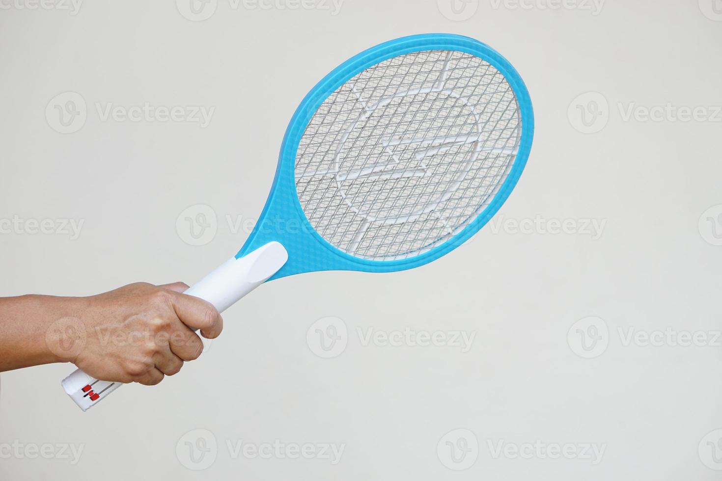 Closeup hand holds mosquito electric swatter racket. Concept, electric device to kill mosquitoes, insects, bugs by swatting to flying insects. photo