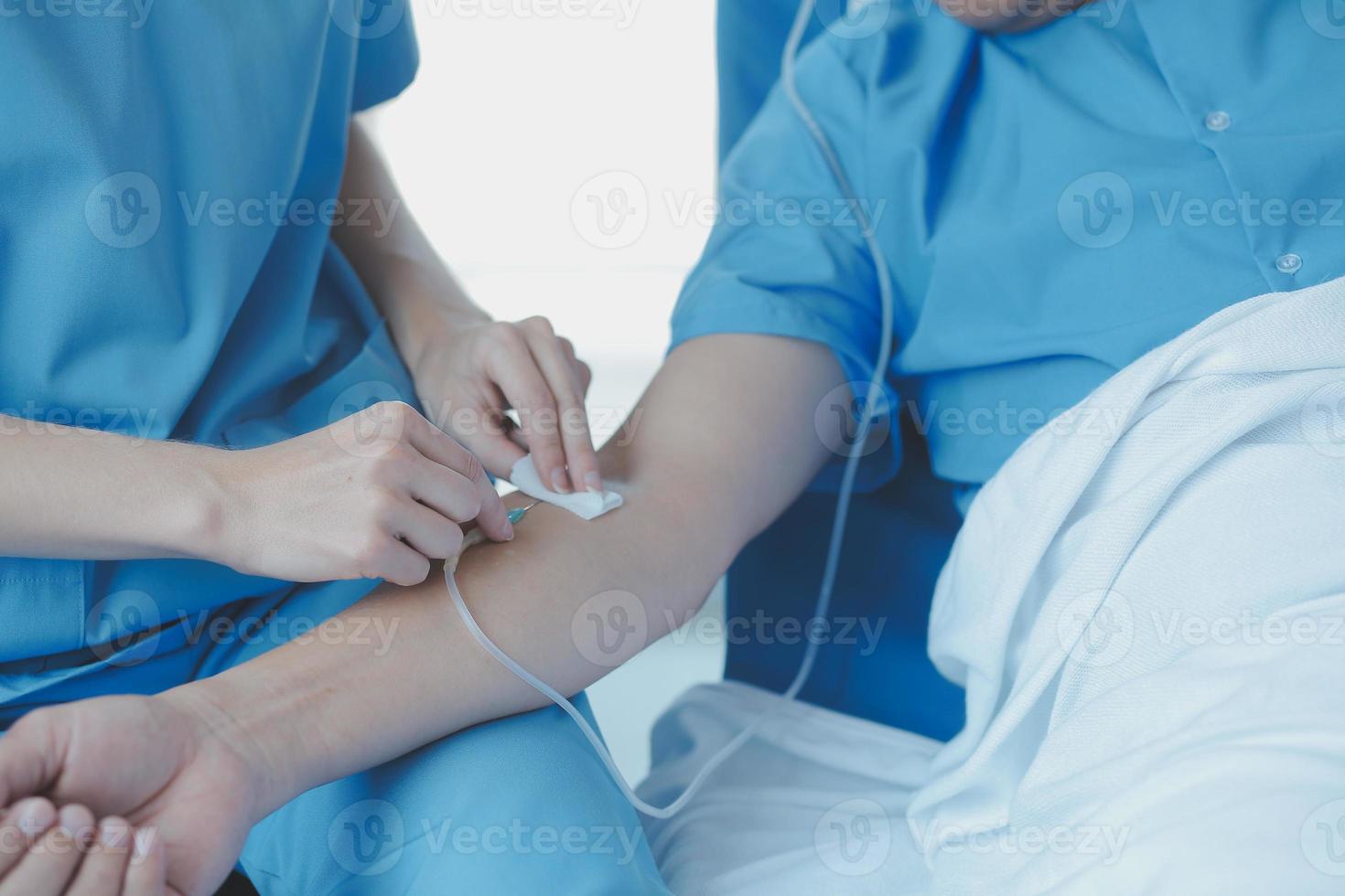 Injured patient showing doctor broken wrist and arm with bandage in hospital office or emergency room. Sprain, stress fracture or repetitive strain injury in hand. Nurse helping customer. First aid. photo