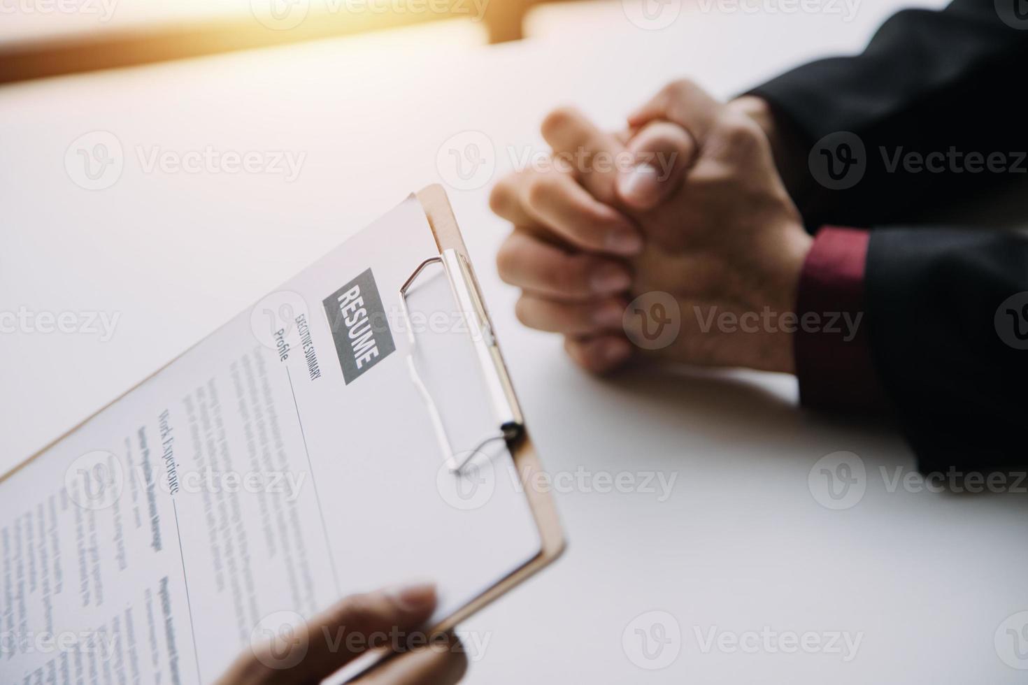Businessman or job seeker review his resume on his desk before send to finding a new job with pen, necktie, glasses and digital tablet. photo
