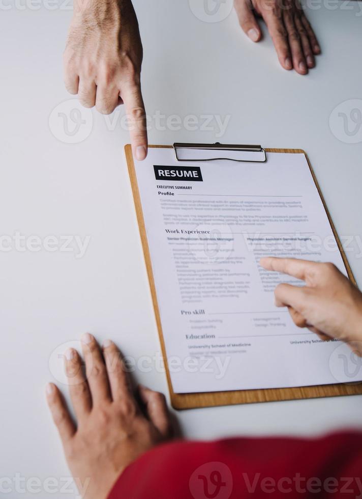 Businessman or job seeker review his resume on his desk before send to finding a new job with pen, necktie, glasses and digital tablet. photo