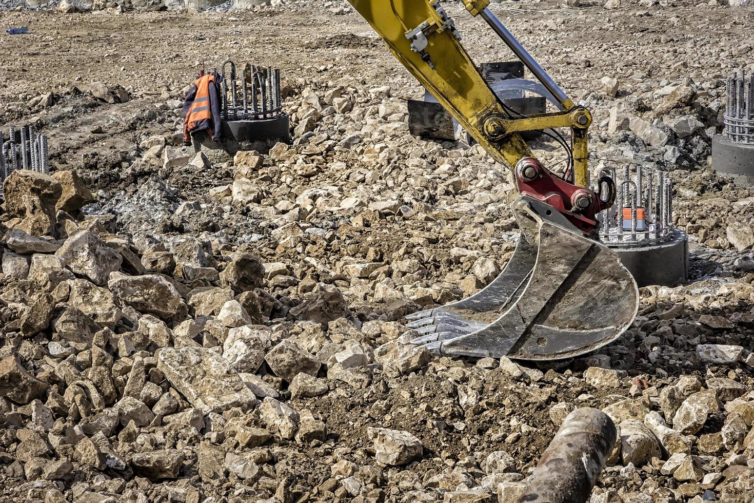 View of a part of single excavator arm with hydraulic Hoses and cylinder at a construction site. Close photo