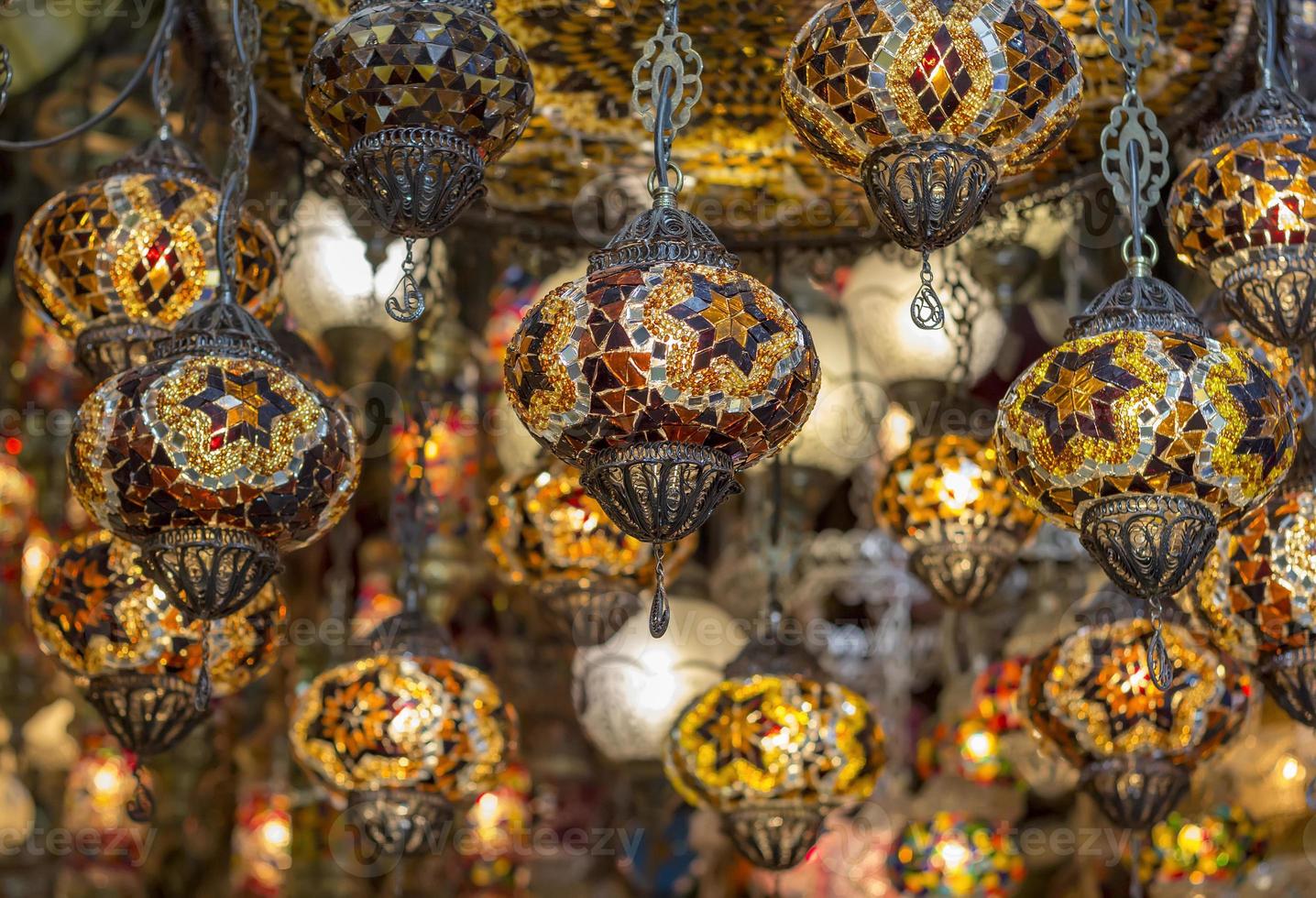 Amazing traditional handmade turkish lamps in souvenir shop. Mosaic of colored glass. Lit in the evening, creating a cozy atmosphere photo