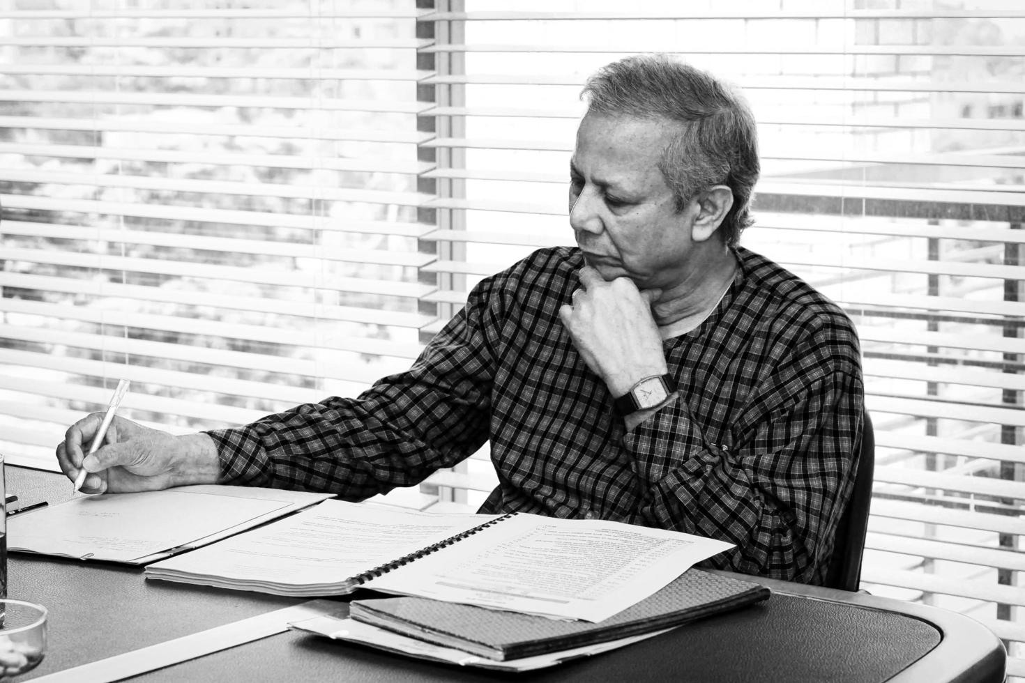 Bangladesh September 20, 2012, Muhammad Yunus a popular economist and leader is writing on the table at a conference at Grameen centre, Dhaka. photo