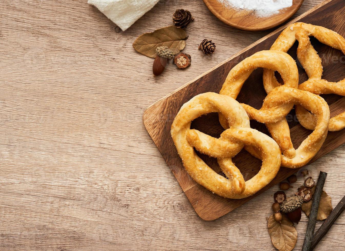 top view or flat lay group of pretzel in wood plate on wooden table background. photo