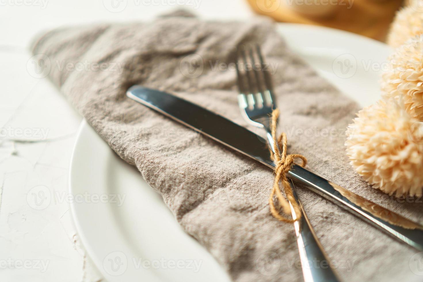 food concept stylish table setting cutlery on white table with silver fork and knife photo