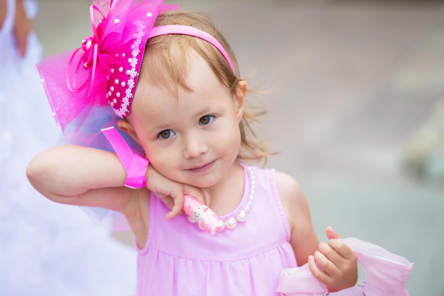 Funny little girl in with a bouquet of flowers at a wedding. photo