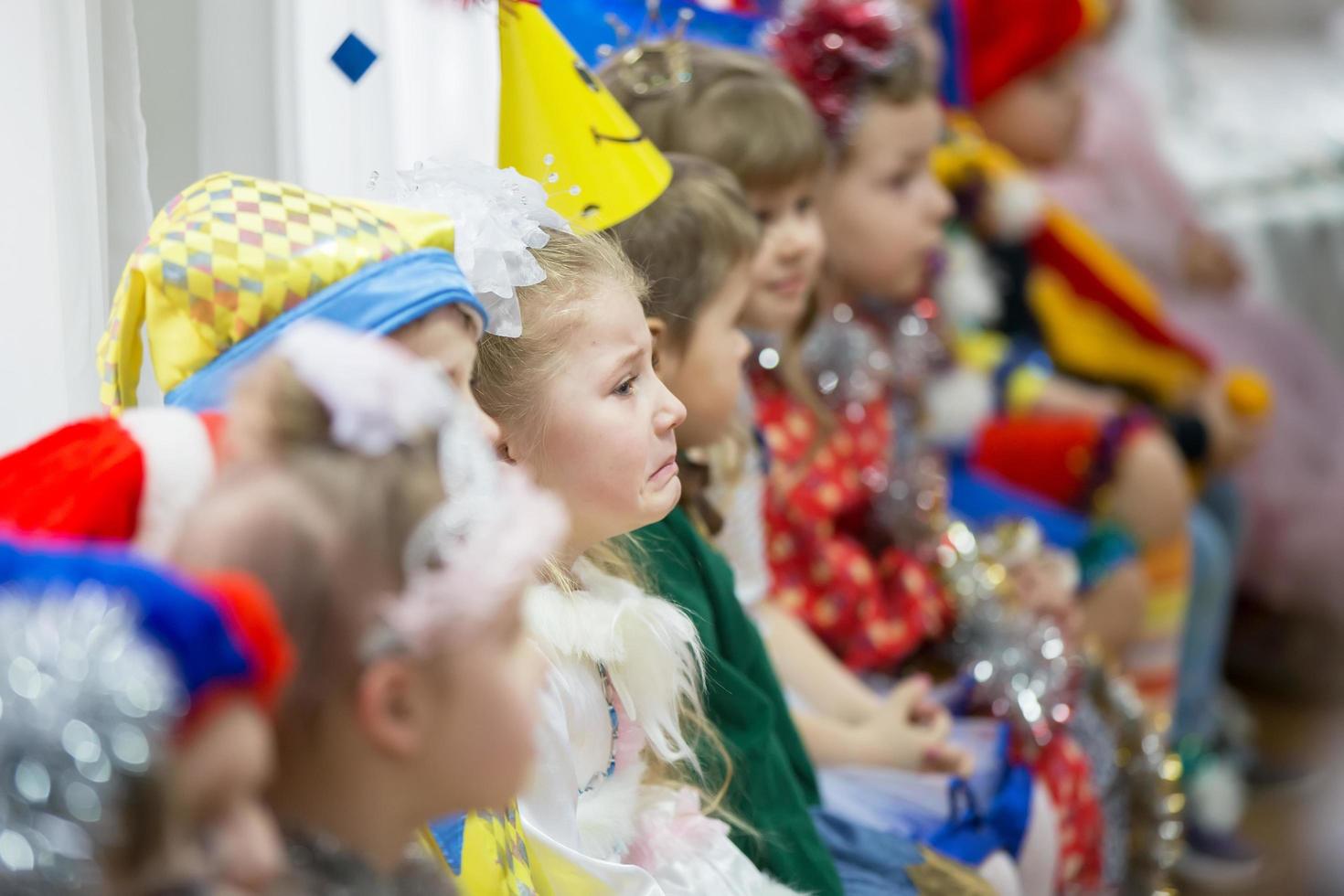 grupo de niños en día festivo. el cara de un triste niño entre contento niños. foto