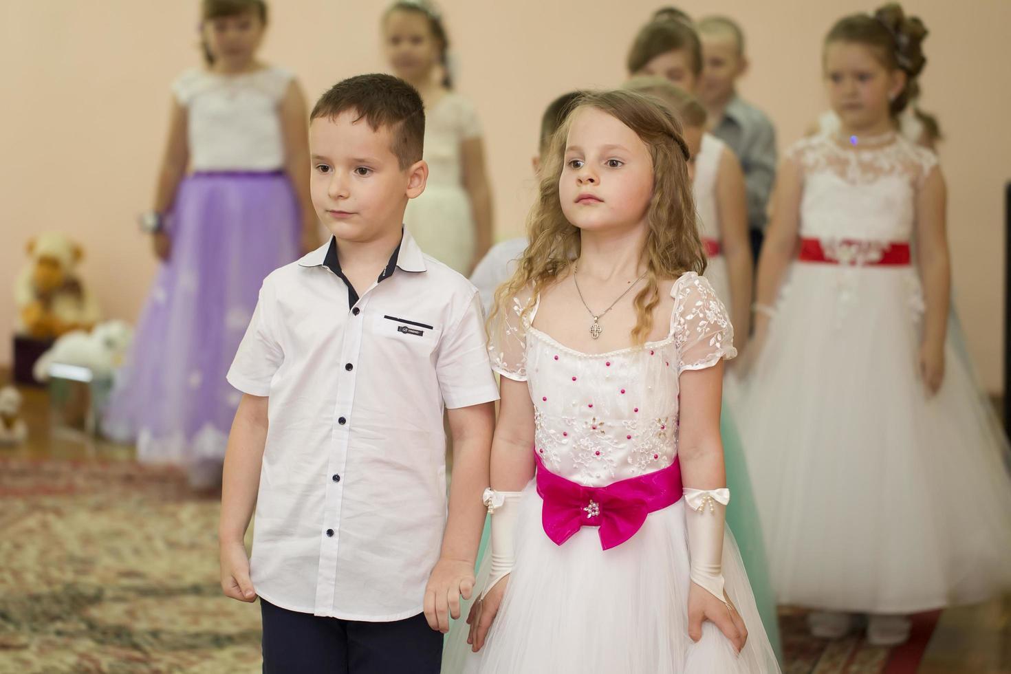 . Dressed up boy and girl are preschoolers. Children perform in kindergarten. photo