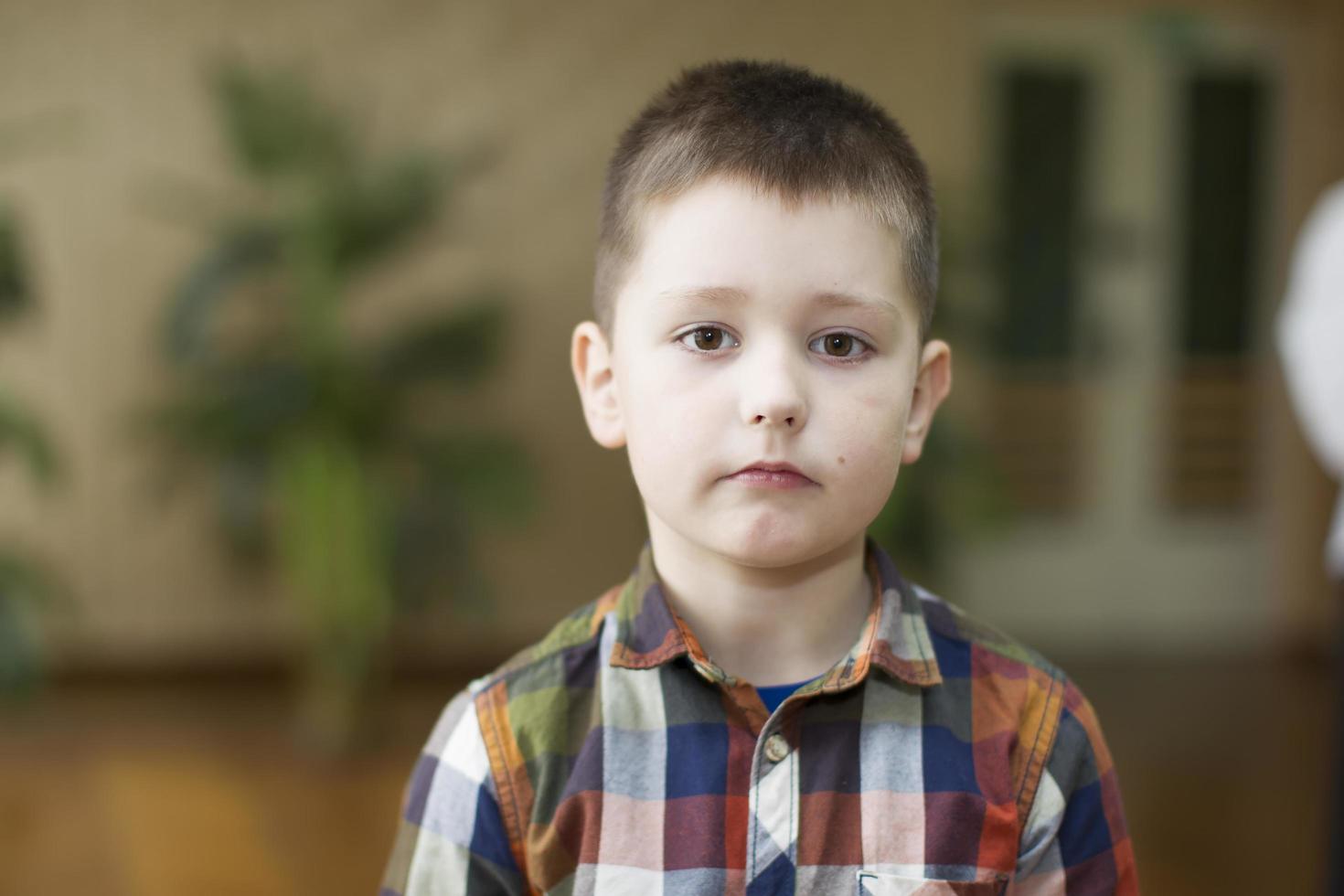 Close-up portrait of a serious preschooler boy. photo