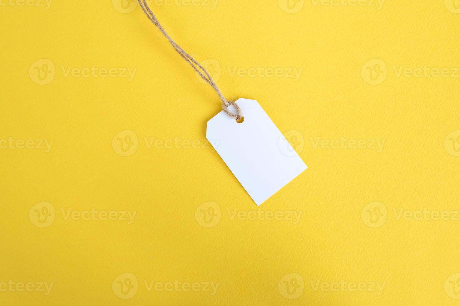 blanco etiqueta con un hilo en un amarillo antecedentes. blanco precio etiqueta etiqueta Bosquejo. sitio a Copiar. foto