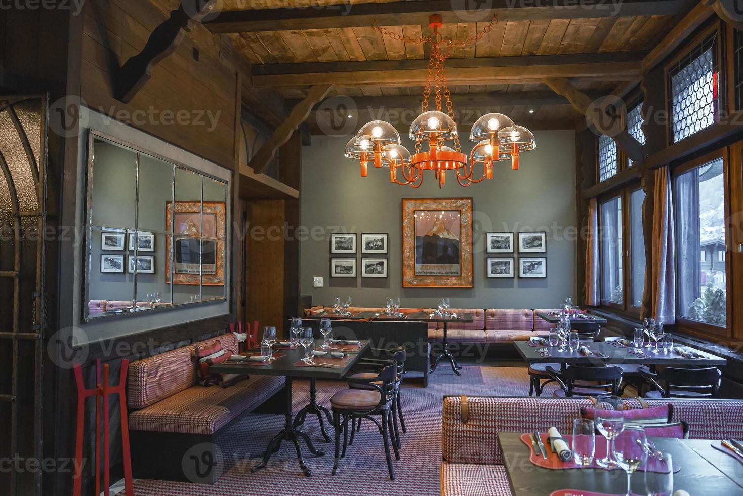 Illuminated chandelier hanging over furniture in luxury restaurant photo