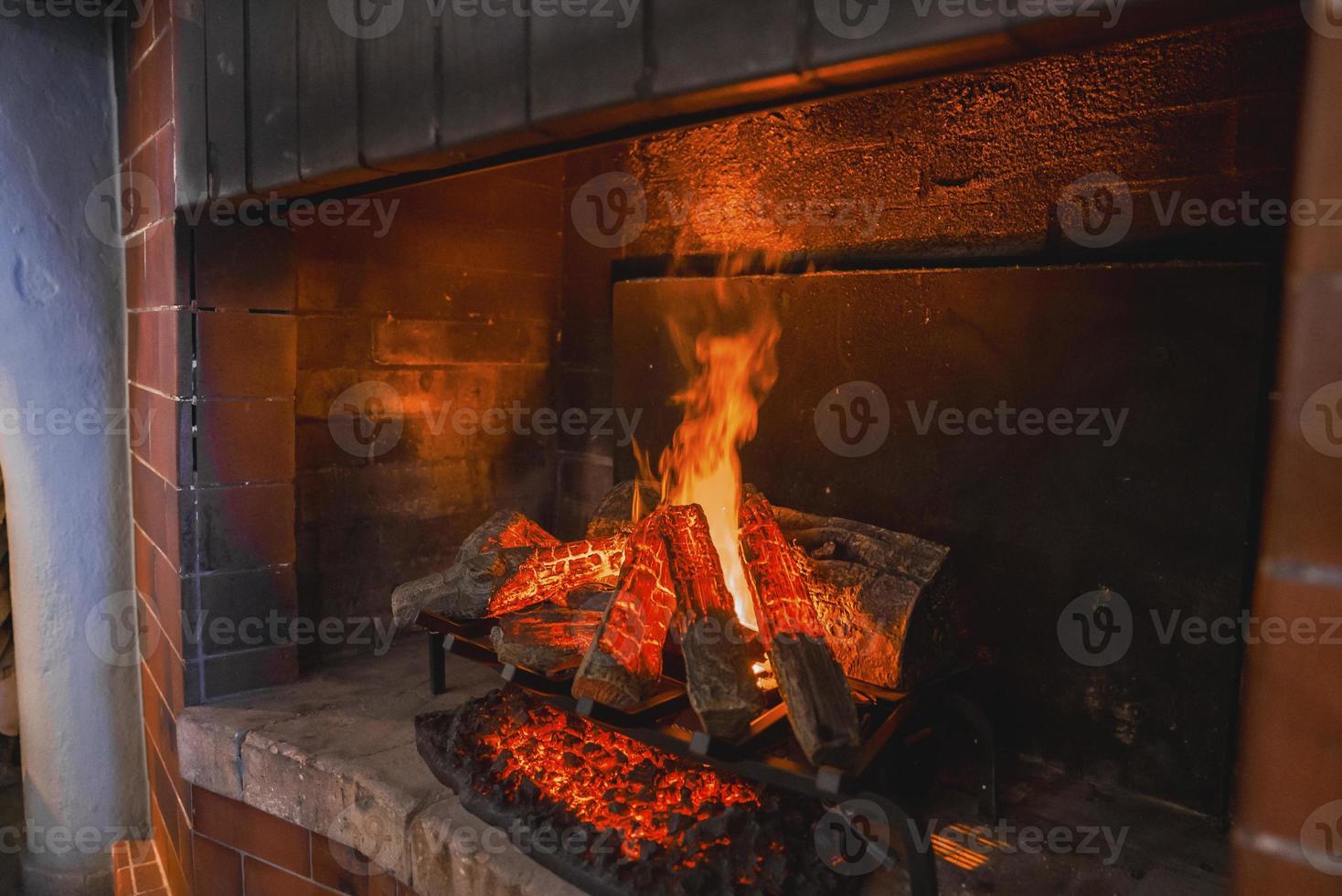 Closeup of firewood burning in fireplace in hotel room photo