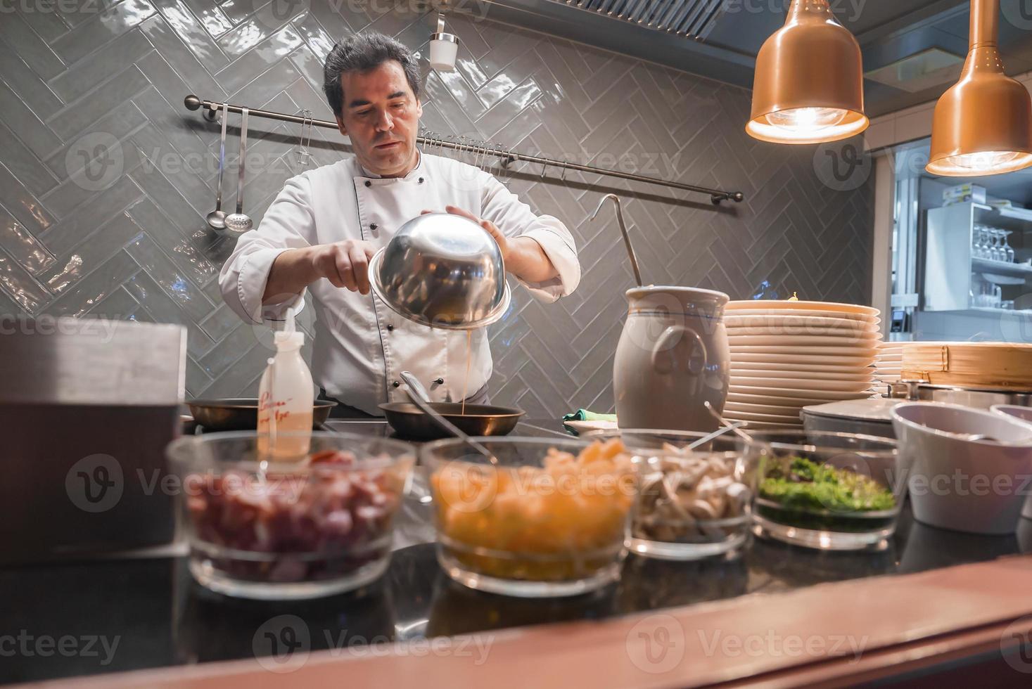 Chef cooking food in commercial kitchen at luxury hotel photo