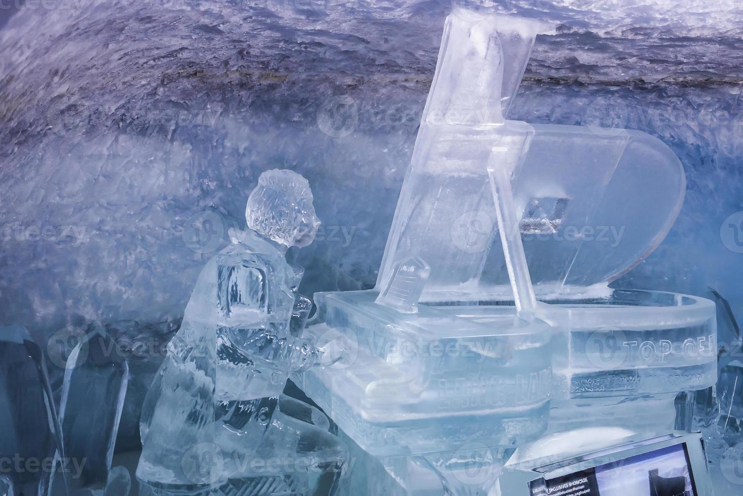 Ice statue of man playing piano in glacier tunnel photo