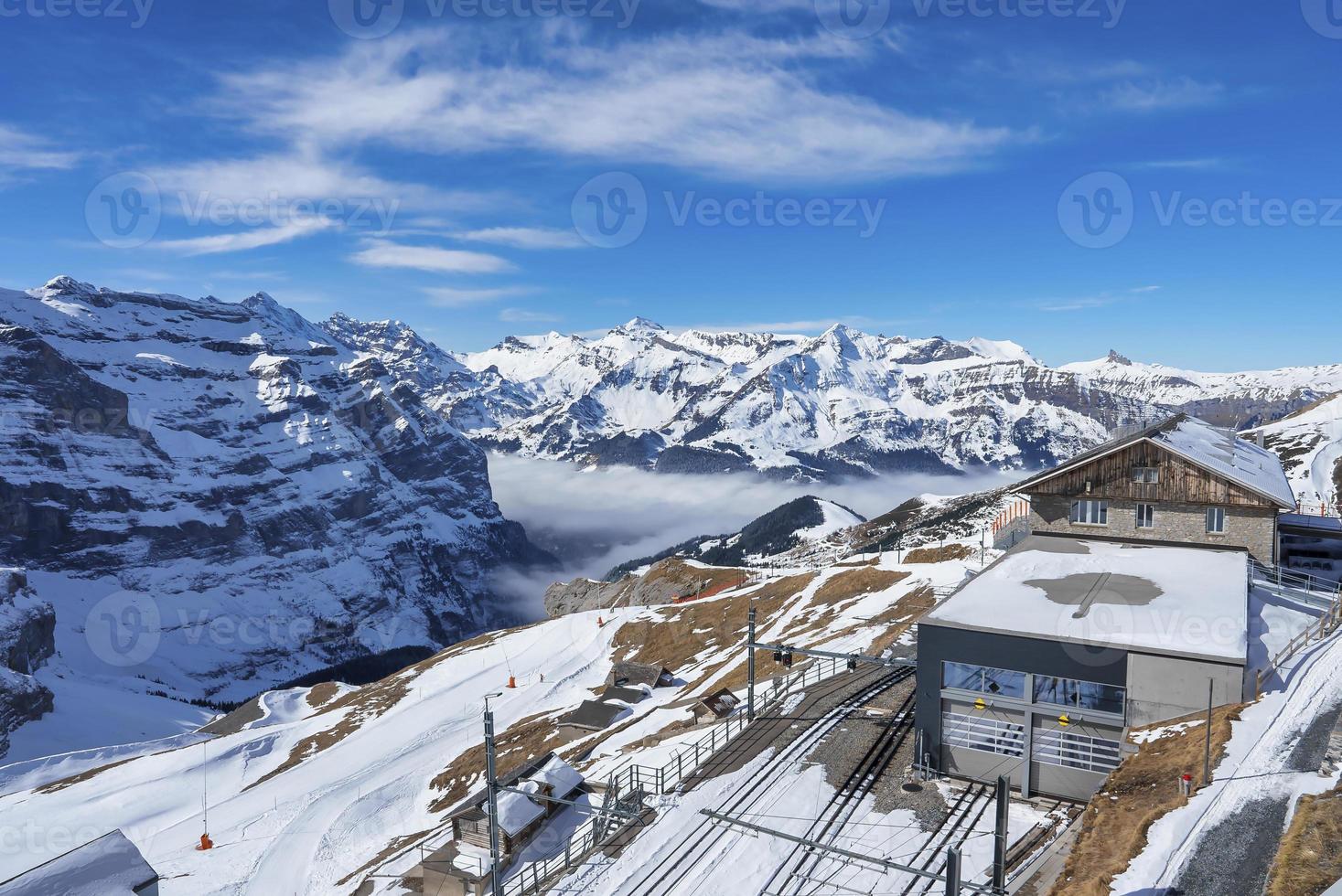 edificios y ferrocarril pistas con majestuoso nevado montañas foto