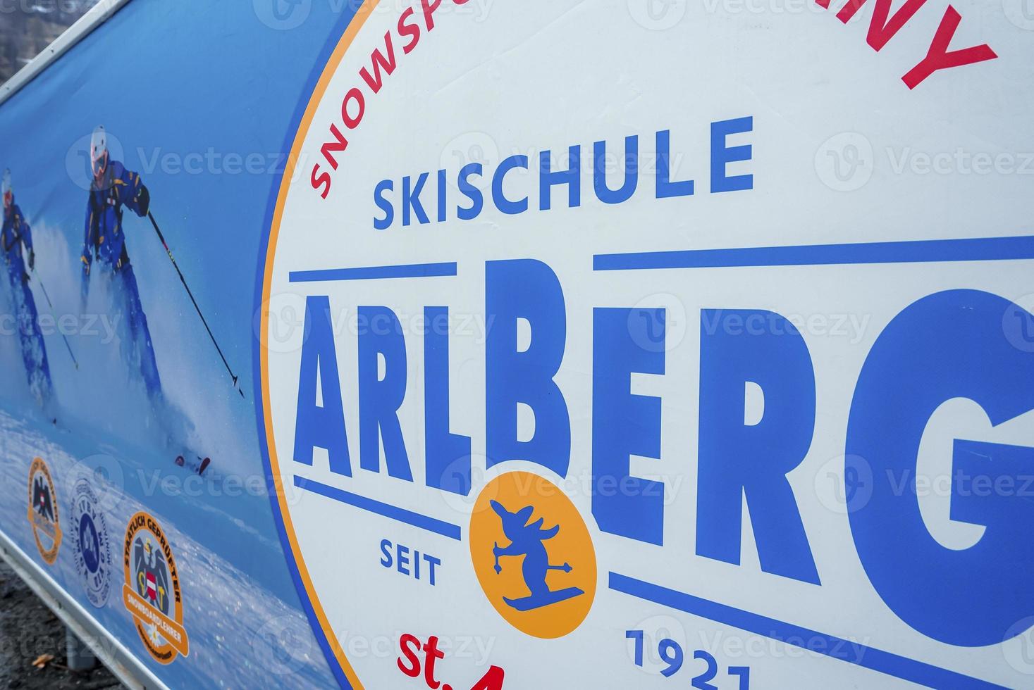 Sign board with Arlberg text with skiing pictures at ski resort photo