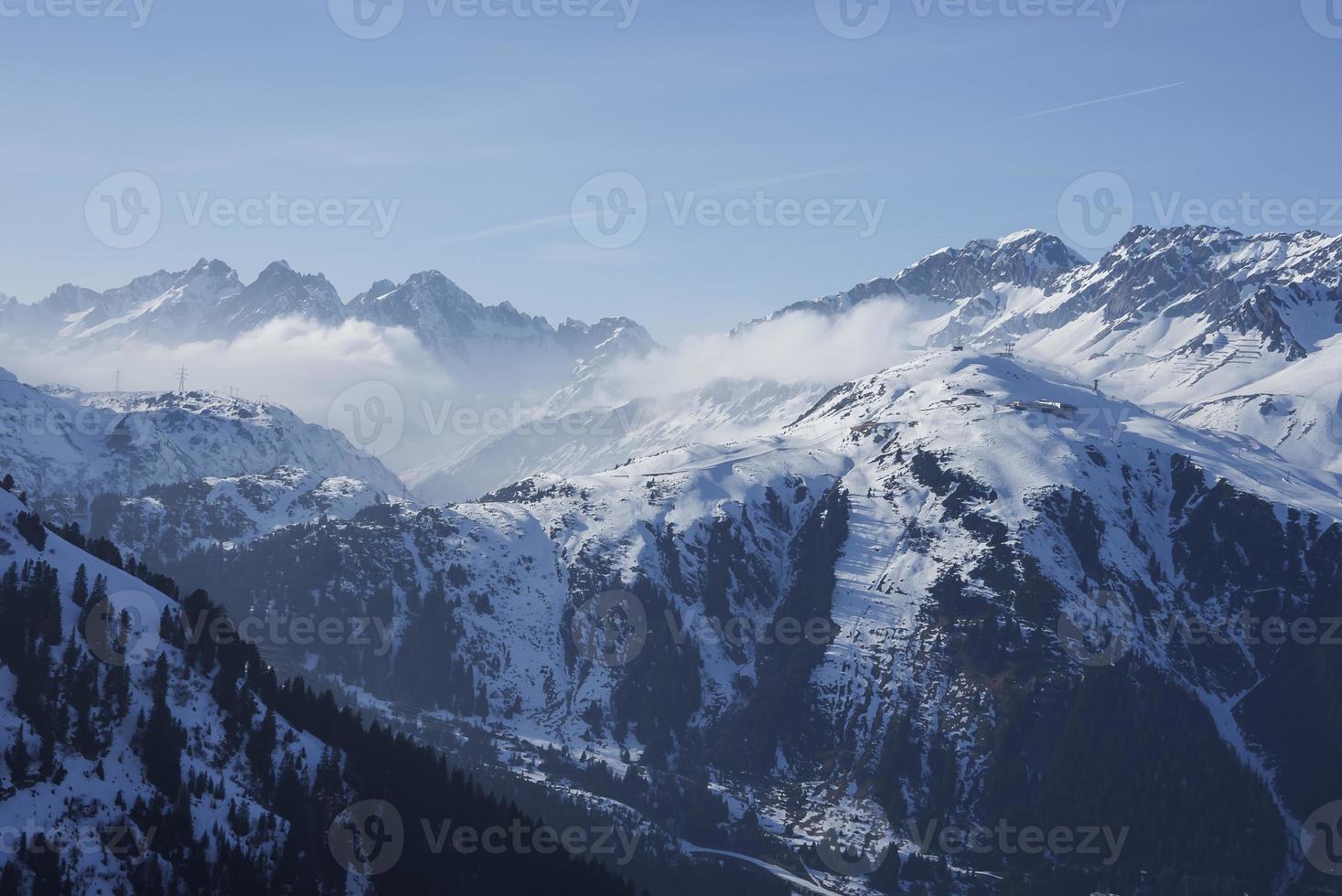 Snow covered landscape with ski resort on sunny day photo