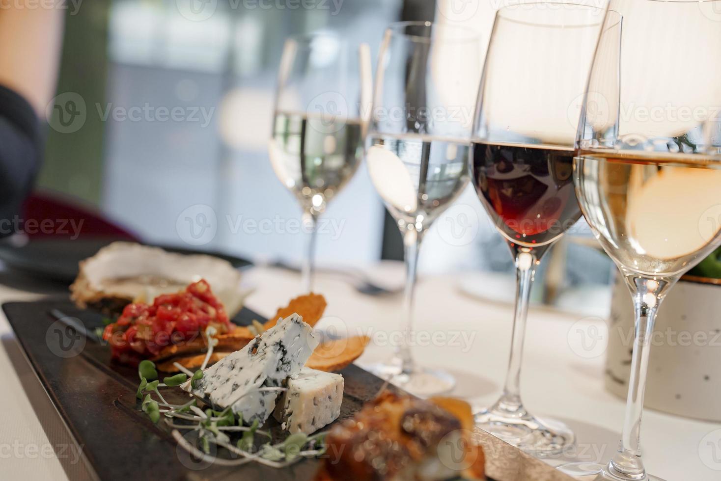 Appetizers with wineglasses on dining table at luxury restaurant photo