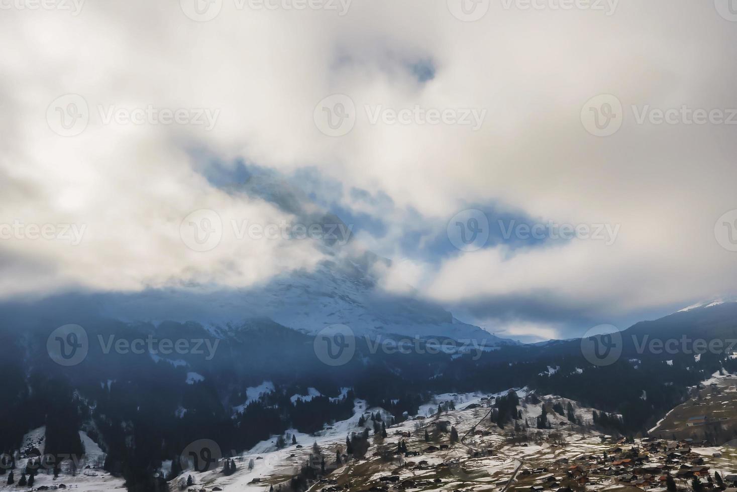 nieve cubierto majestuoso bernés montaña pico debajo Cloudscape durante invierno foto